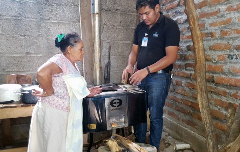 A stove owner talks with an Envirofit Customer Care field team member during an in-home visit