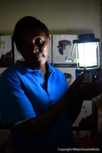 A LivelyHoods sales agent uses a solar lamp